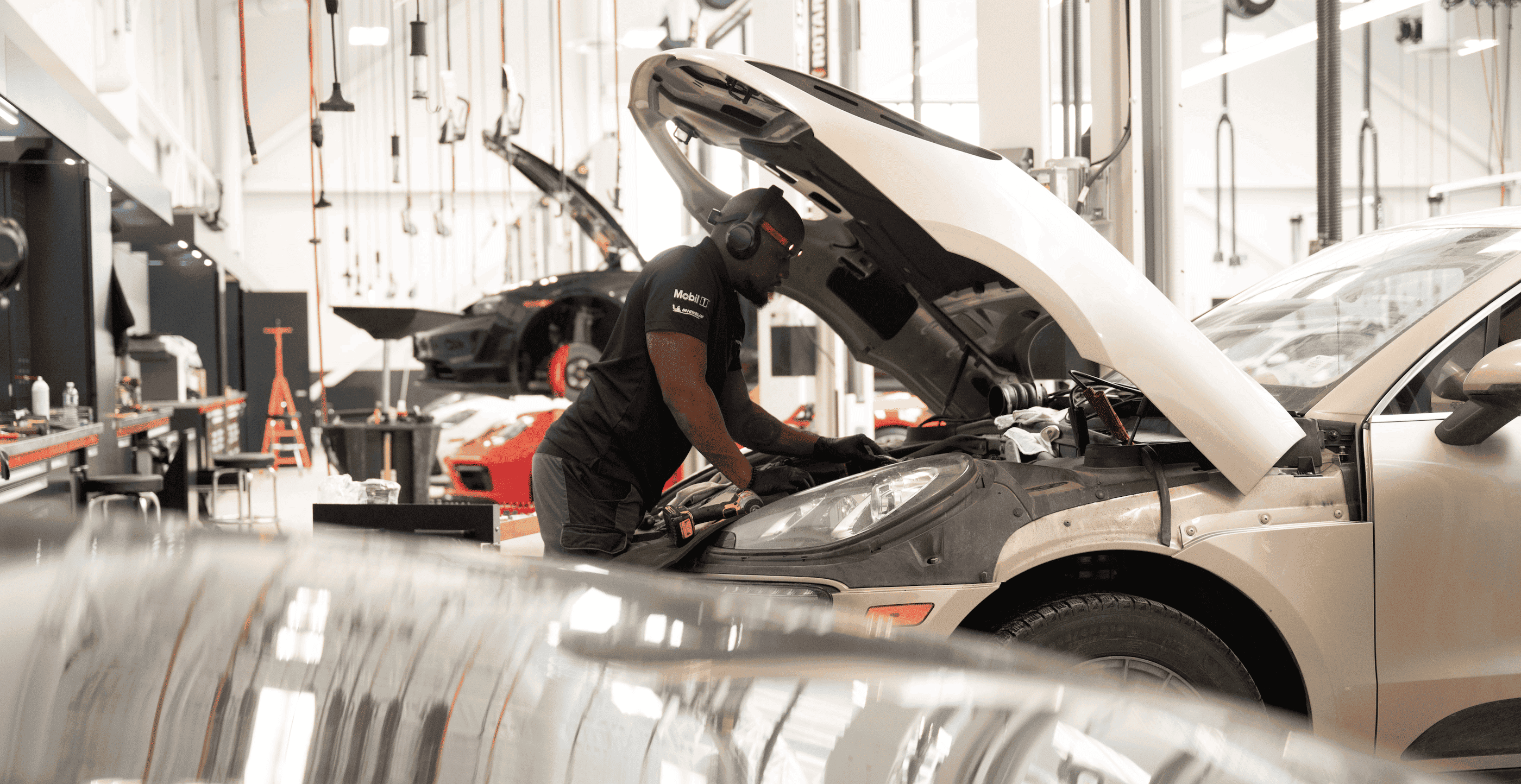 Technician checking the hood of a car in a service department