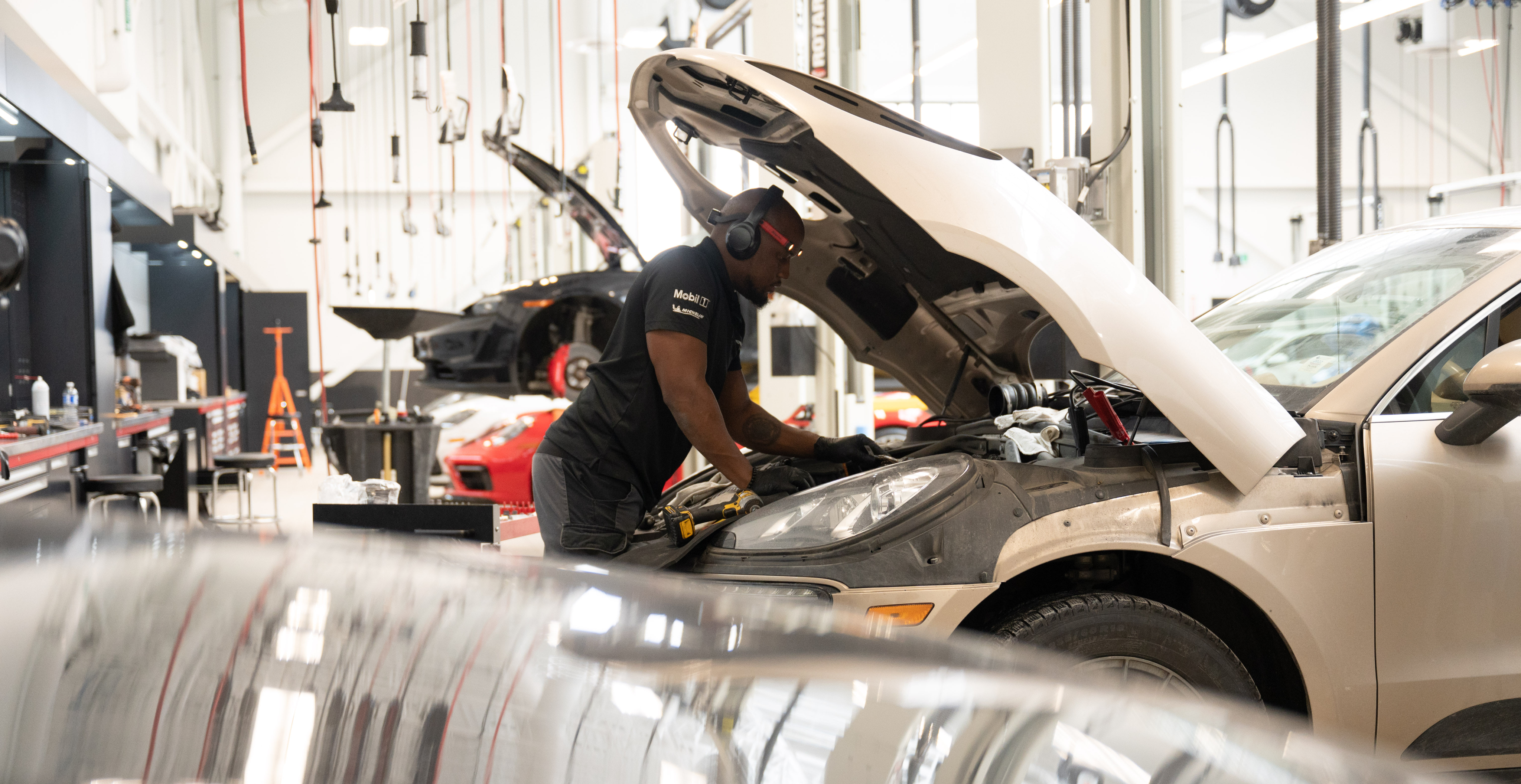 Technician checking the hood of a car in a service department