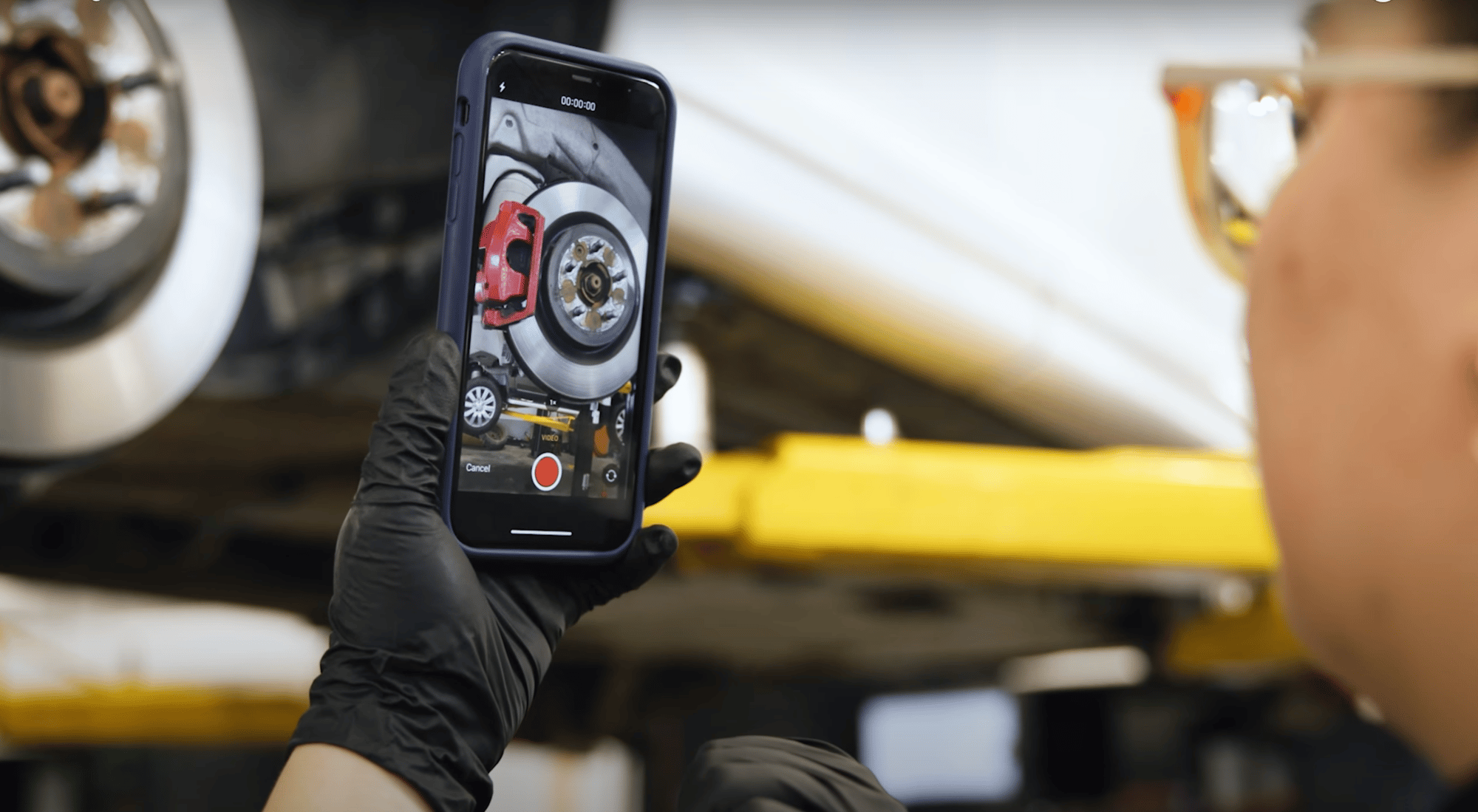 Technician taking a video with her cellphone of a brake