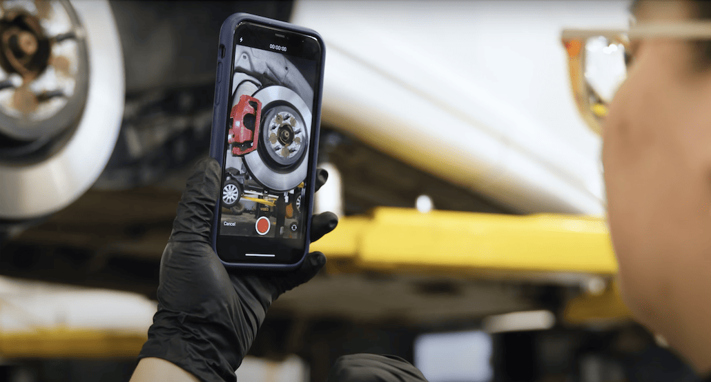 Technicienne qui prend une vidéo d'un frein sur son téléphone mobile