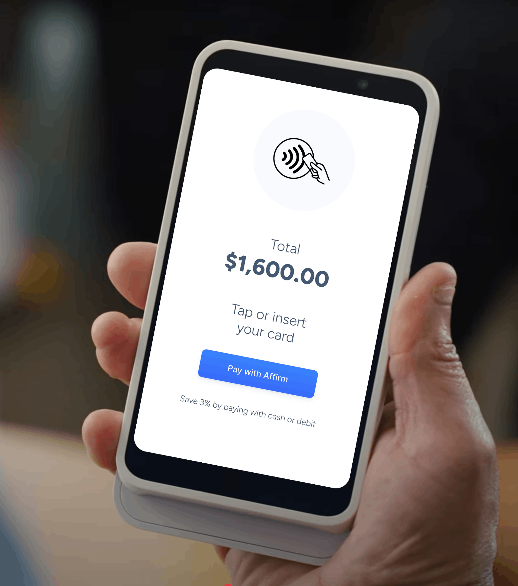 A close-up of a payment terminal screen displaying a total of $1,600.00, prompting the user to tap or insert their card, with an option to “Pay with Affirm” and a note offering a 3% savings for paying with cash or debit.
