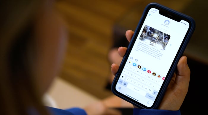 A person holding a smartphone displaying a messaging app conversation with their service advisor..