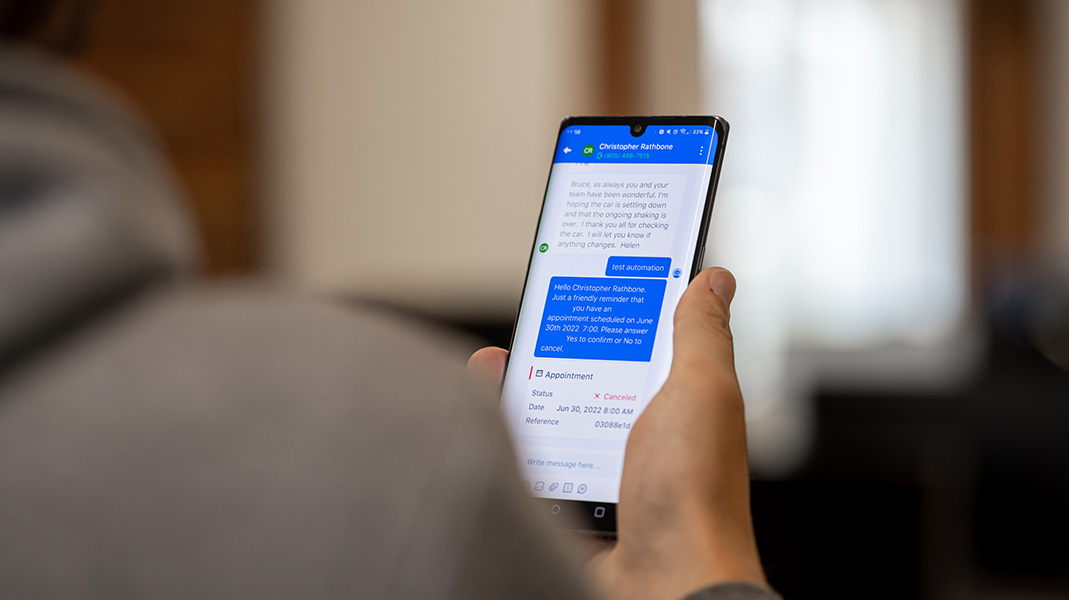 Client receiving text message about their appointment at dealership service center