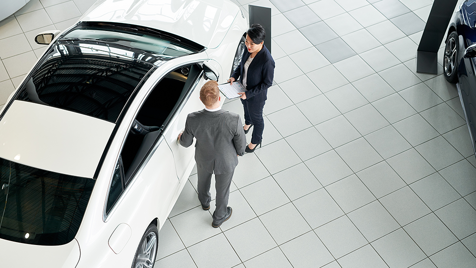A customer in a dealership showroom with a sales person